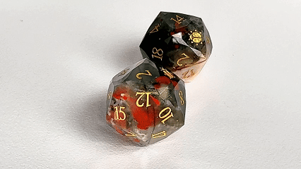 Two natural bloodstone DND D20 dice engraved with "Khepri's Blessing" are spinning. | Bear Dice