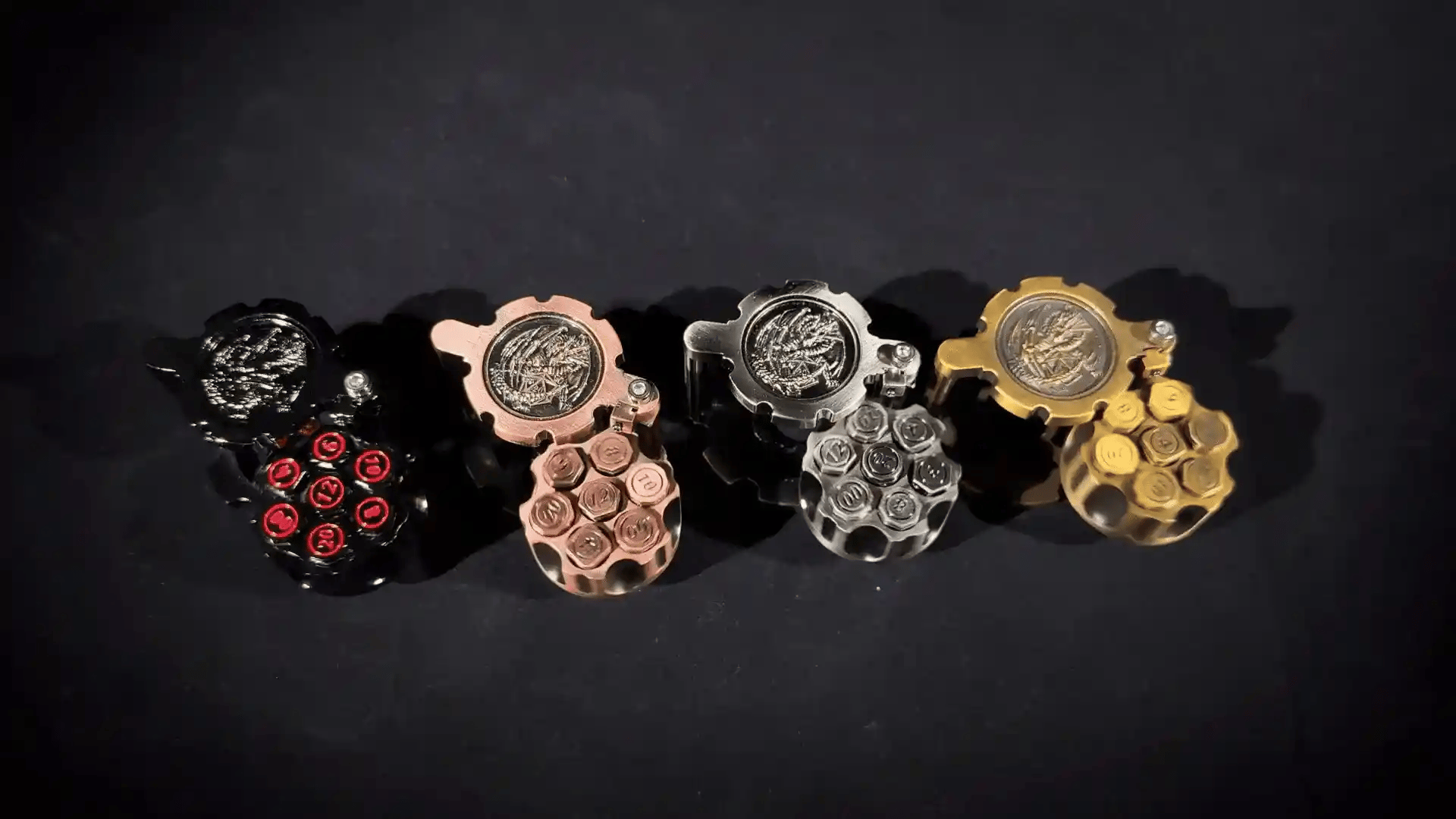 Four different colored revolver bullet dice sets (Antique Nickel, Antique Gold, Copper, and Black Nickel Red) are arranged on a black tabletop. | Bear Dice