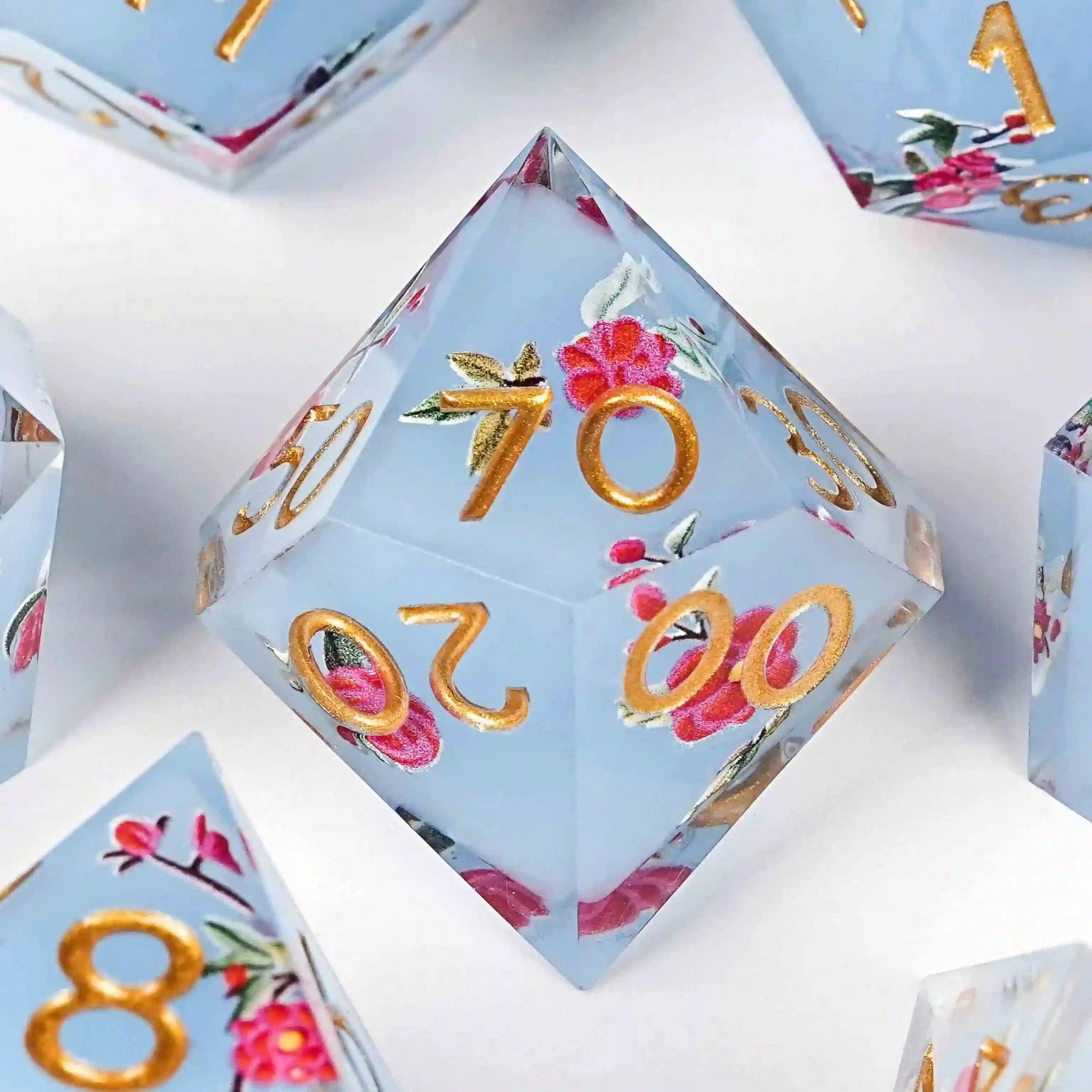 Light blue resin DND D% dice with sharp edges and a light red floral pattern | Bear Dice