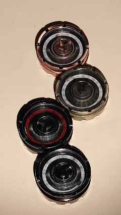 Metal D20 roulette dice spinners in 4 different colors (black, bronze, copper, purple and green gradient) are spinning smoothly and at high speed | Bear Dice