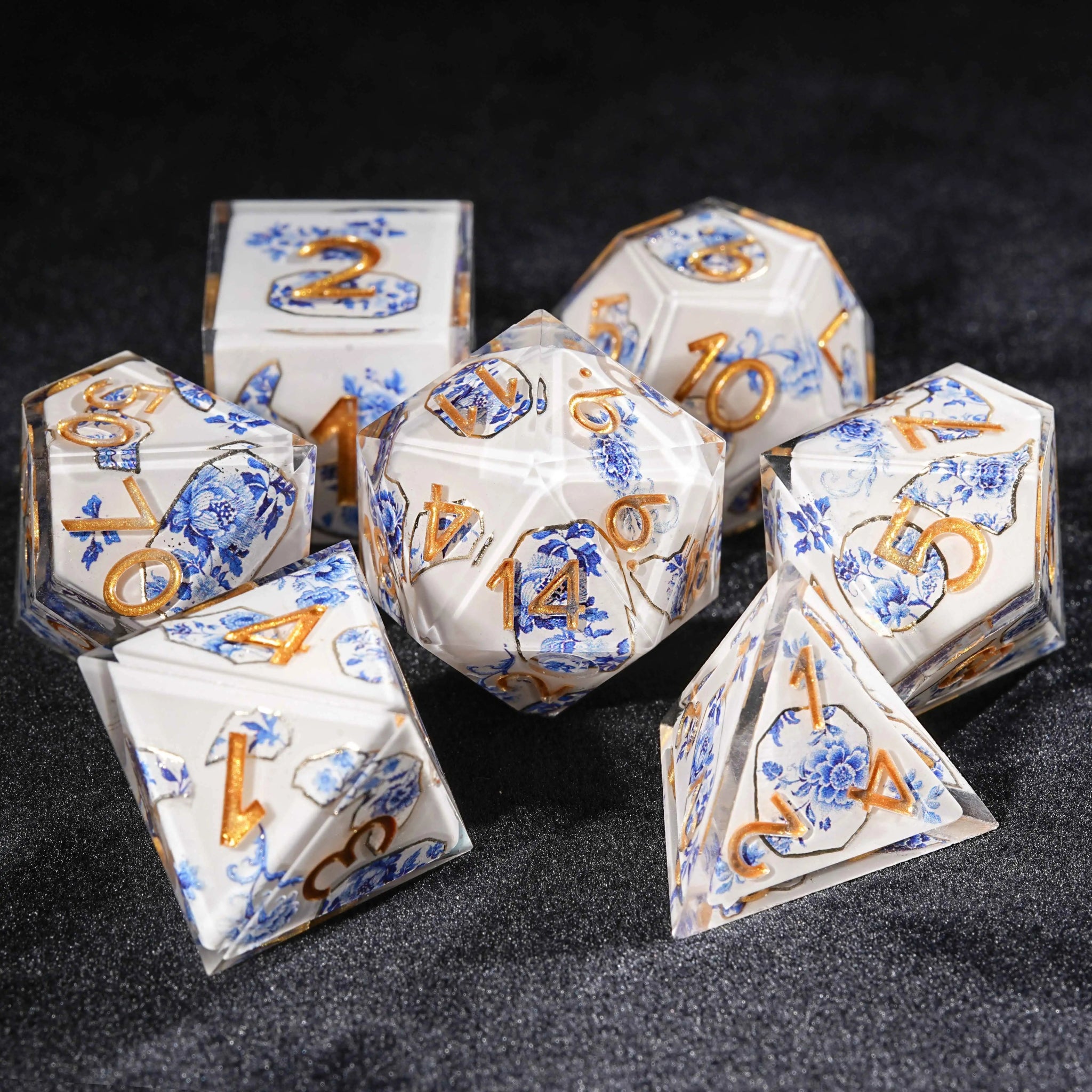 Transparent resin Oriental Blue and White Porcelain DND dice set, featuring a blue and white porcelain fragment pattern with blue flowers and plants, and engraved gold numbers | Bear Dice