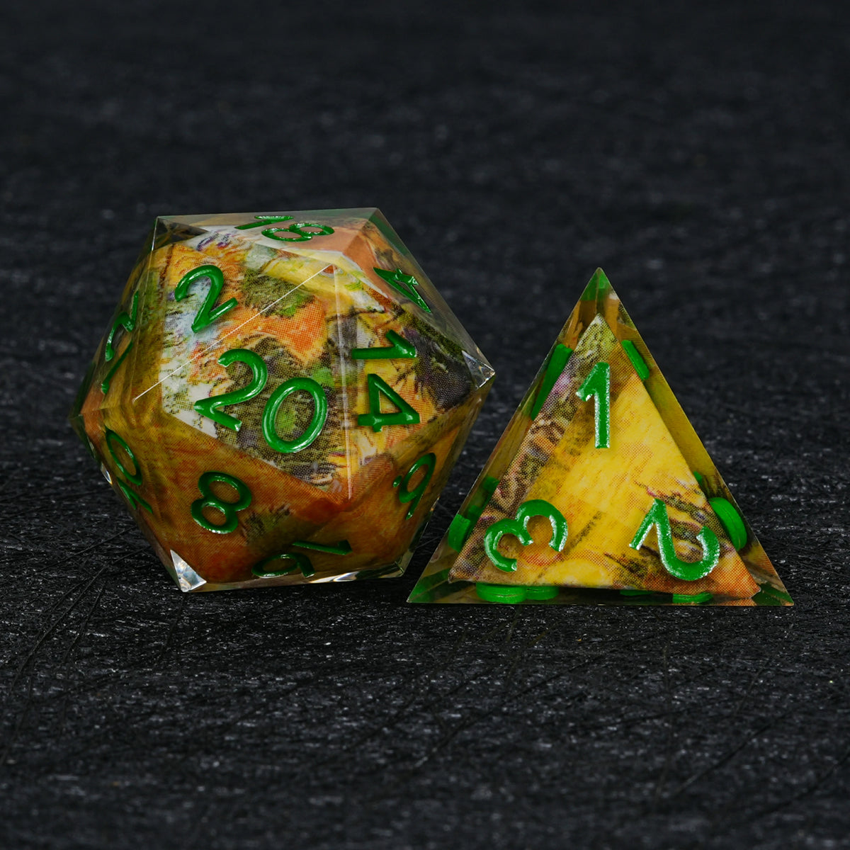 Resin D20 and pyramid-shaped D4 with autumn landscape artwork in orange, yellow and olive green, paired with green numbers