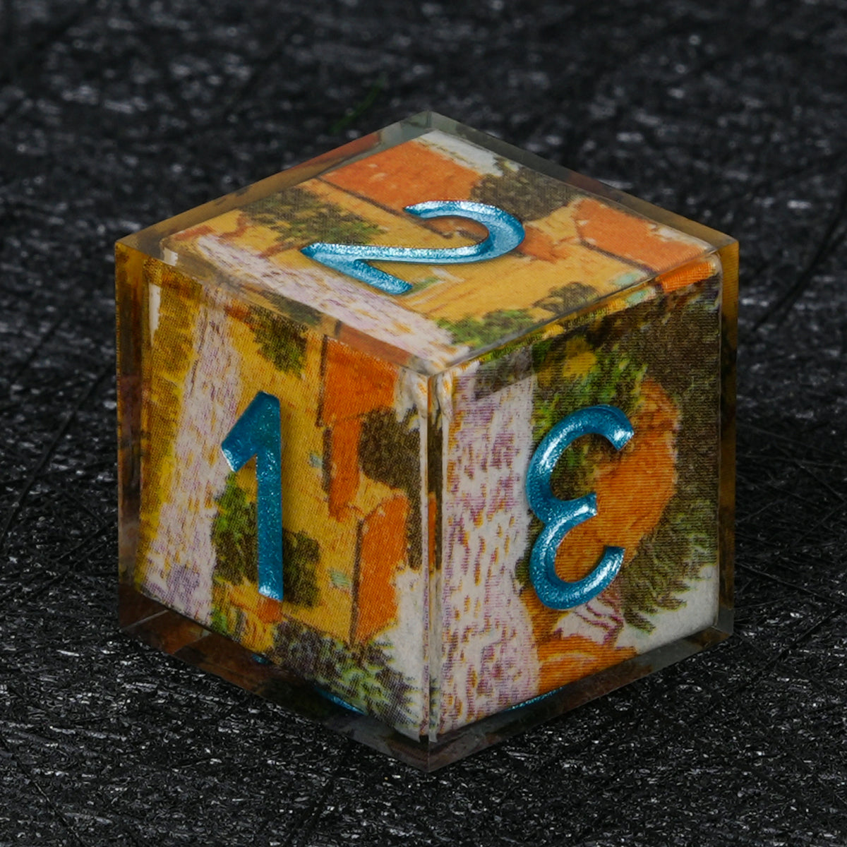 Six-sided resin D6 with orange, yellow and green landscape decal artwork and metallic blue numbers