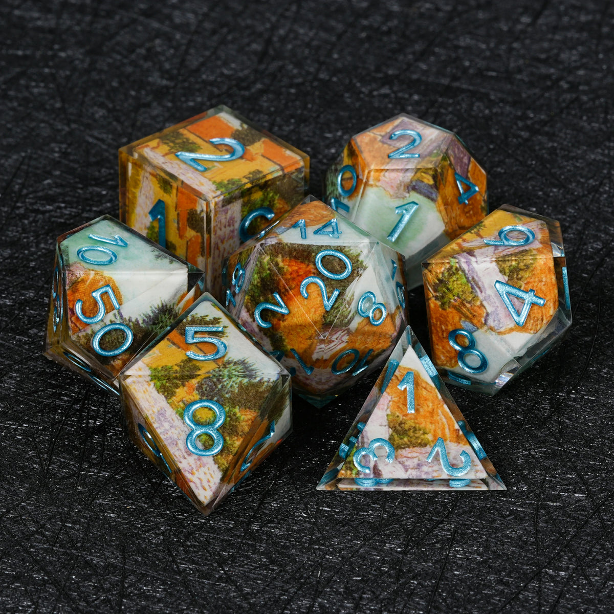 Seven autumn landscape resin dice with metallic blue numbers, including D4, D6, D8, D10, percentile die, D12 and D20