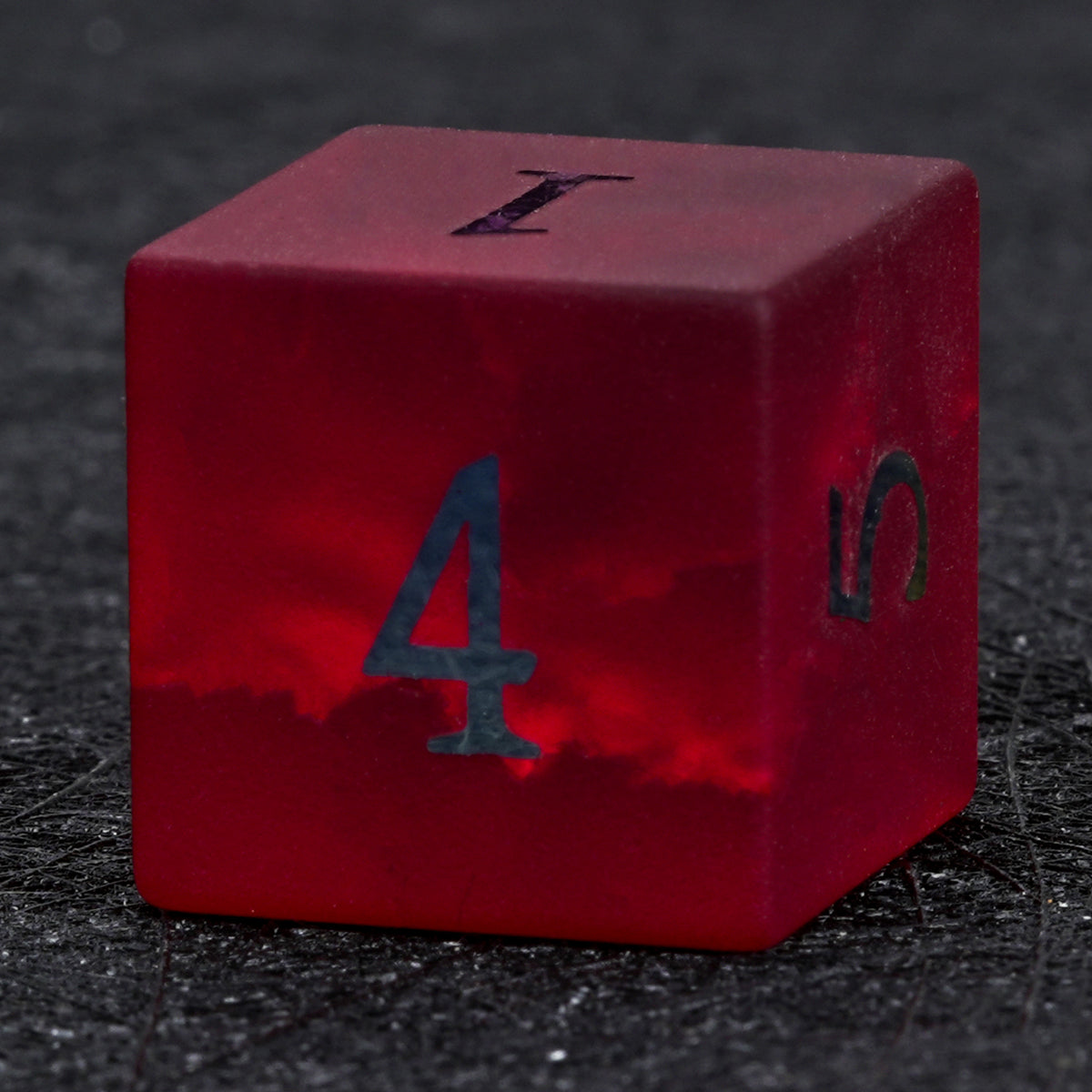 Garnet red frosted glass D6 die with rainbow-plated numbers, showing its cube shape and the number 4 on the front face