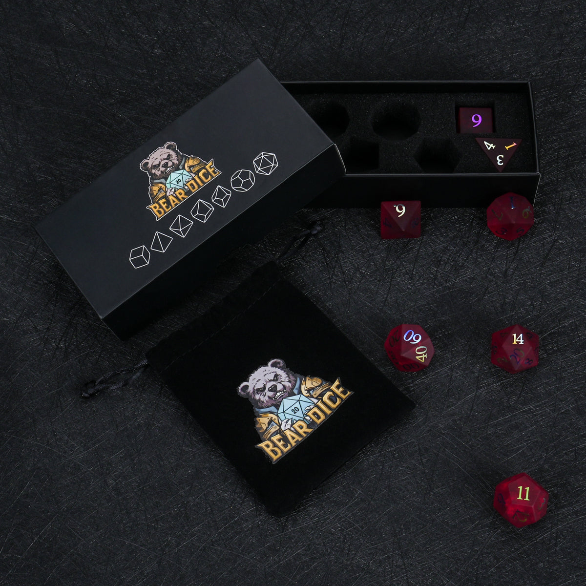 Garnet red frosted glass dice displayed beside black Bear Dice packaging boxes on a dark surface