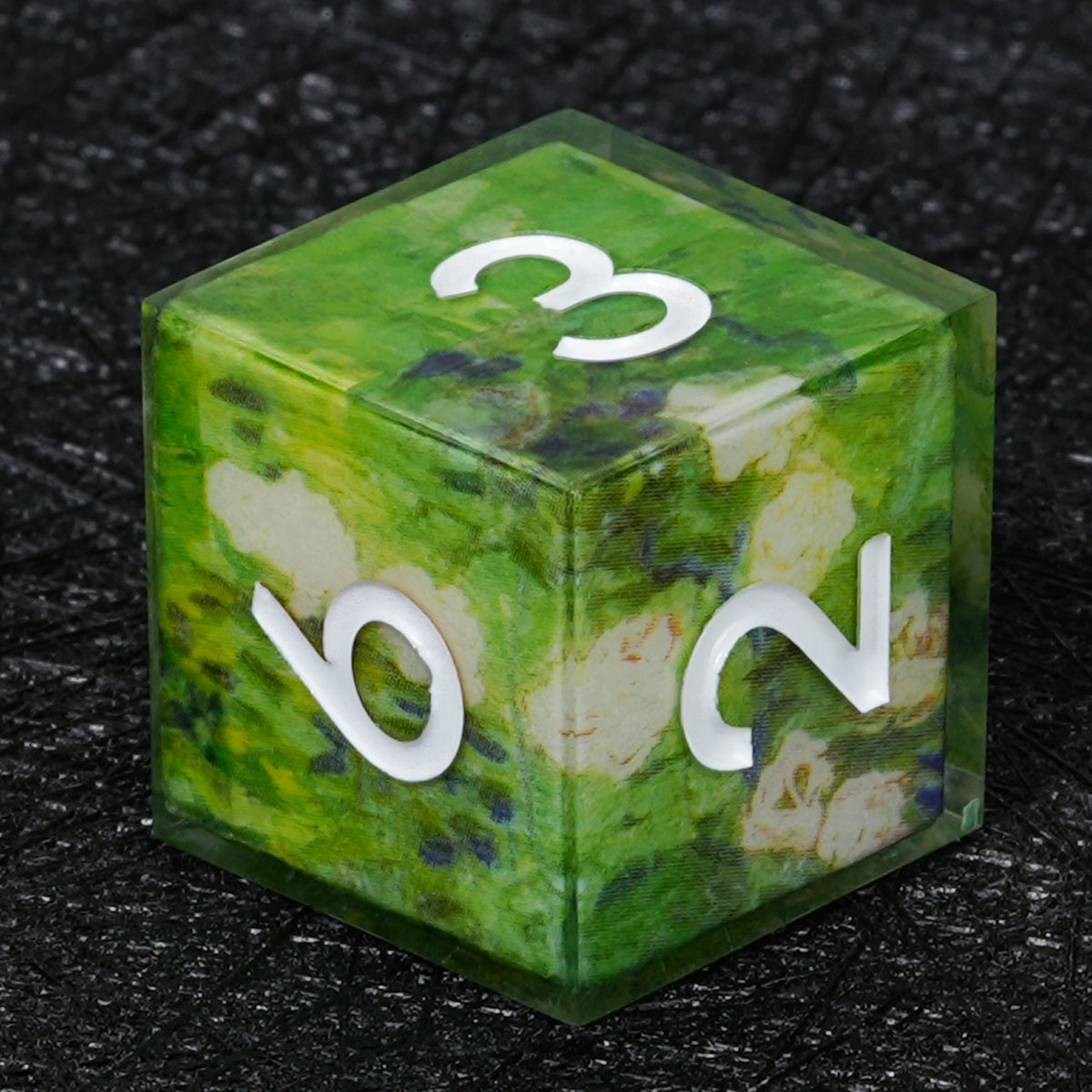 Six-sided green resin D6 with cream-white floral artwork, small blue and yellow accents and white numbers