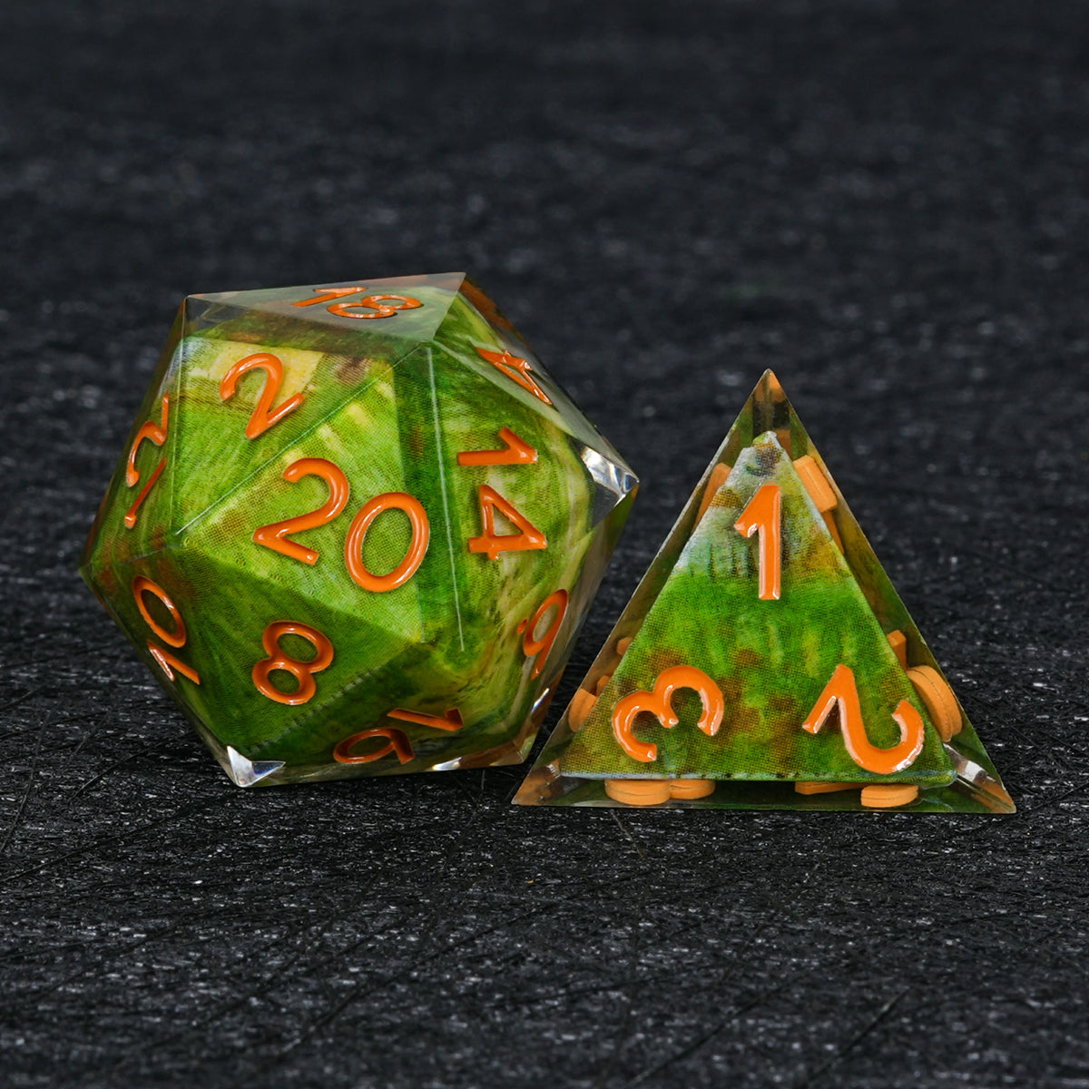 Green landscape resin D20 and pyramid-shaped D4 with orange numbers and clear sharp edges