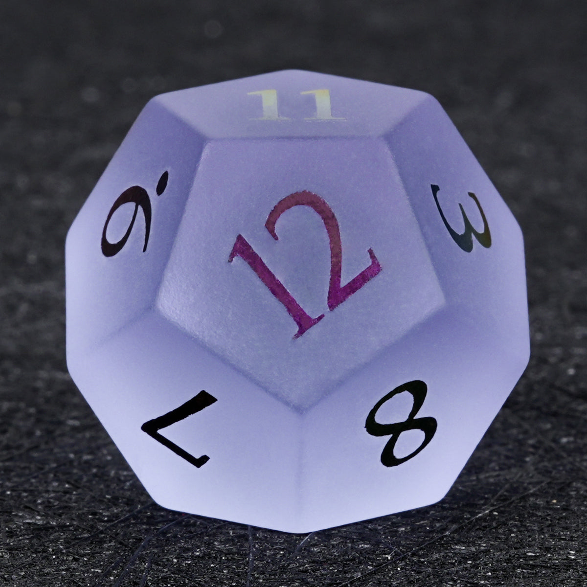 Lavender gemstone D12 die with multicolored numbers, showing the number 12 on the front face against a dark background