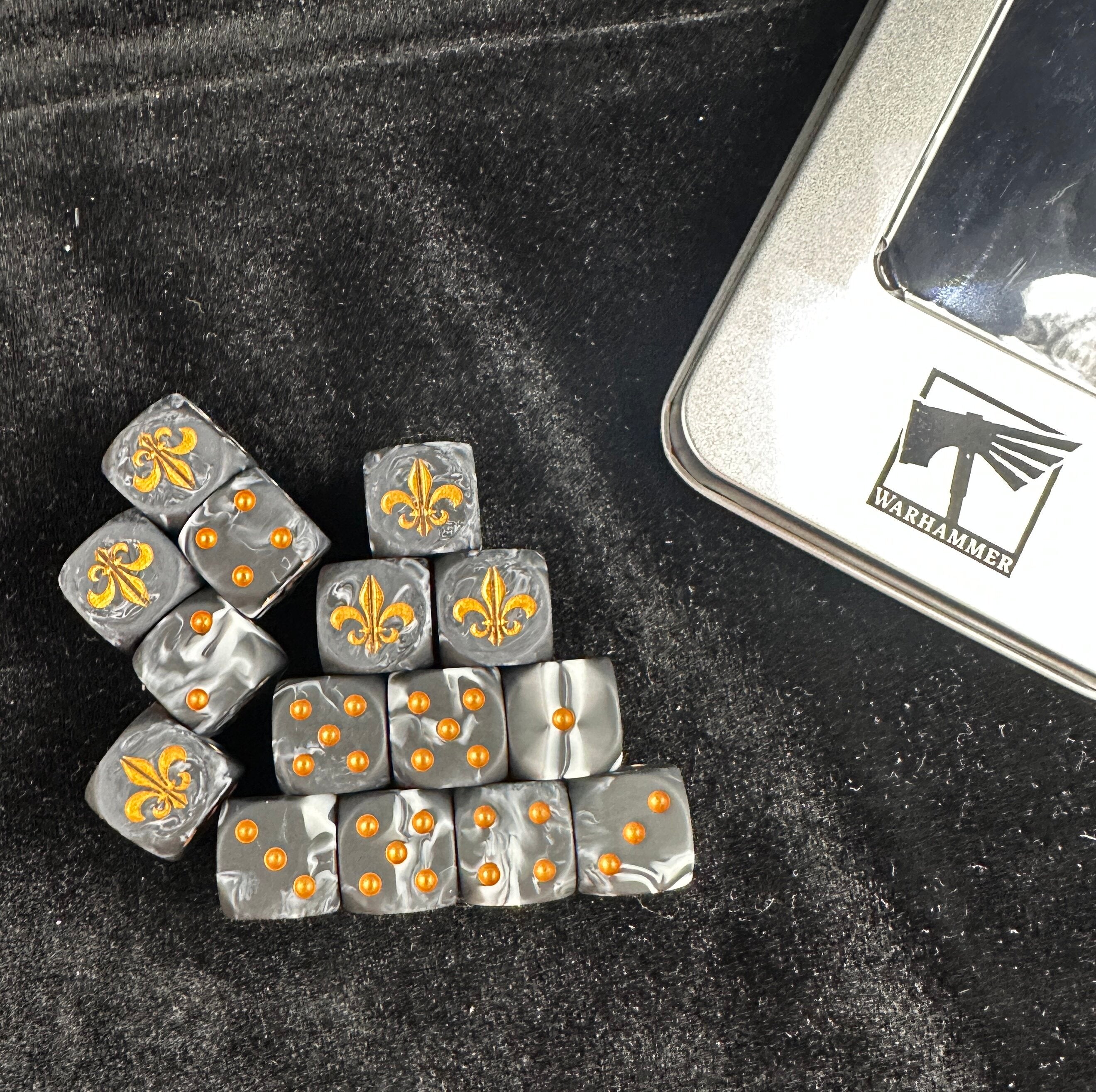Warhammer 40K Battle Fleur-de-lis Black & White Swirl Acrylic D6 Dice — Pyramid Stack of 10 Showing Gold Fleur-de-lis 6-Face and Gold Pip Sides on Dark Background | Bear Dice