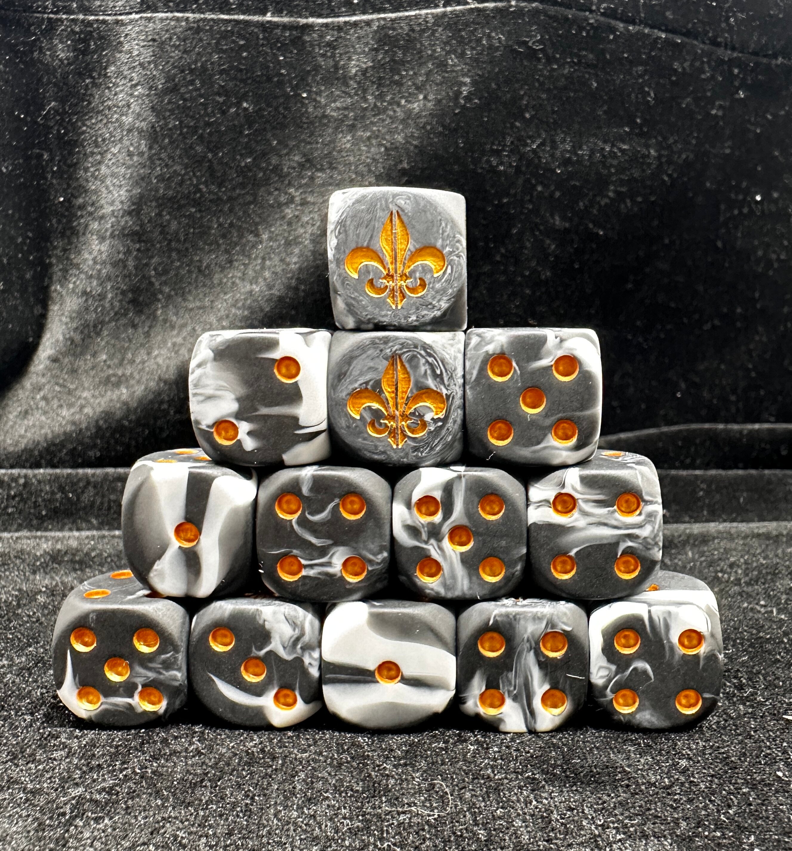 Warhammer 40K Battle Fleur-de-lis Black & White Swirl Acrylic D6 Dice — Pyramid Stack of 10 Showing Gold Fleur-de-lis 6-Face and Gold Pip Sides on Dark Background | Bear Dice