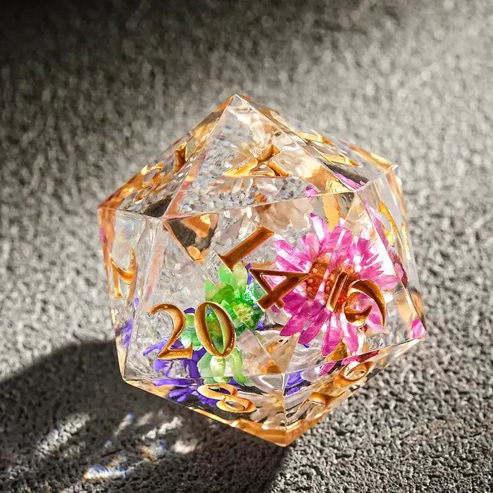 Transparent resin D20 dice with bright dried flowers embedded in it | Bear Dice
