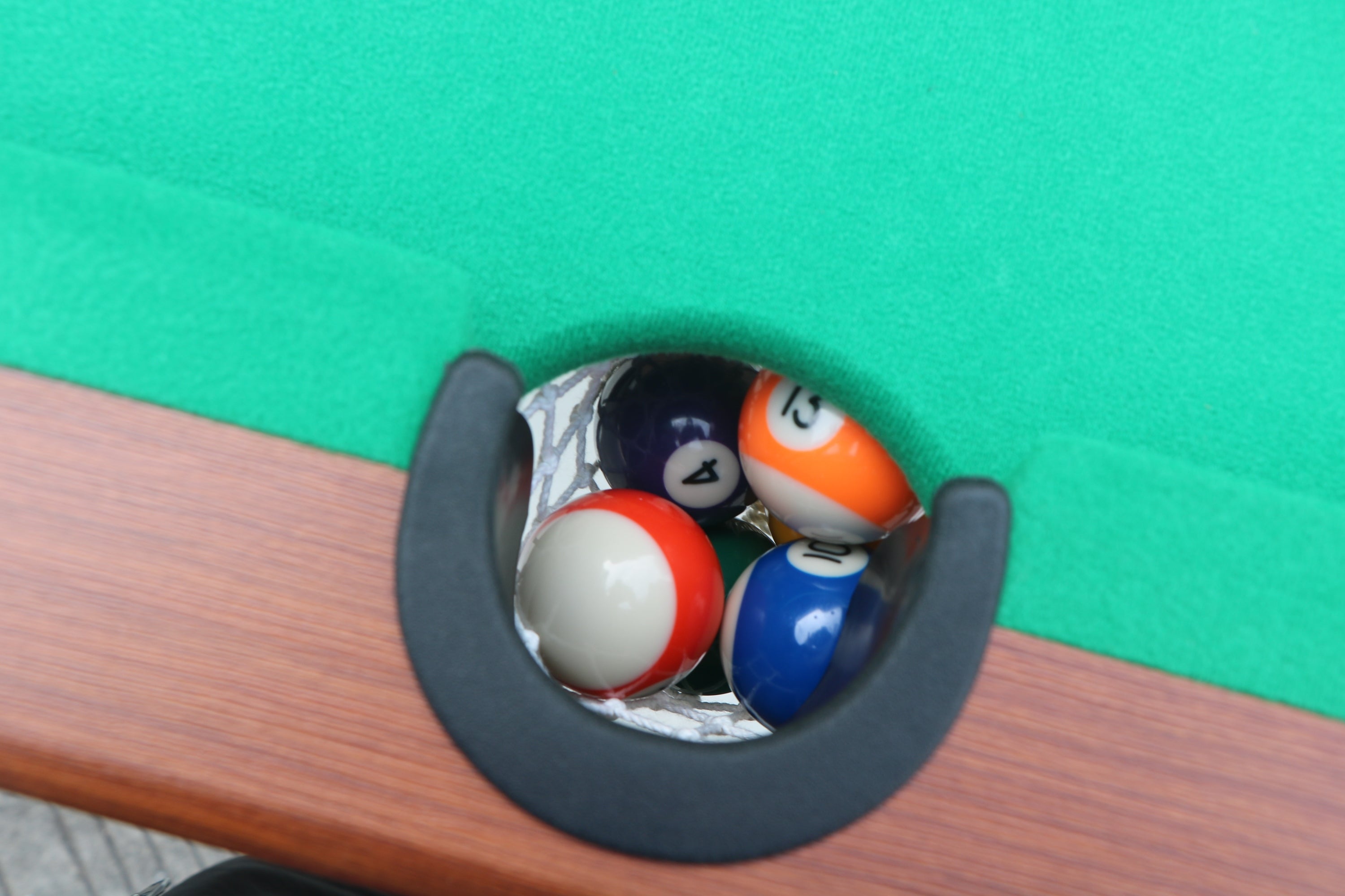 Ball dropping into side pocket net of 63-Inch Green Felt Foldable Wooden Billiard Table | Bear Dice