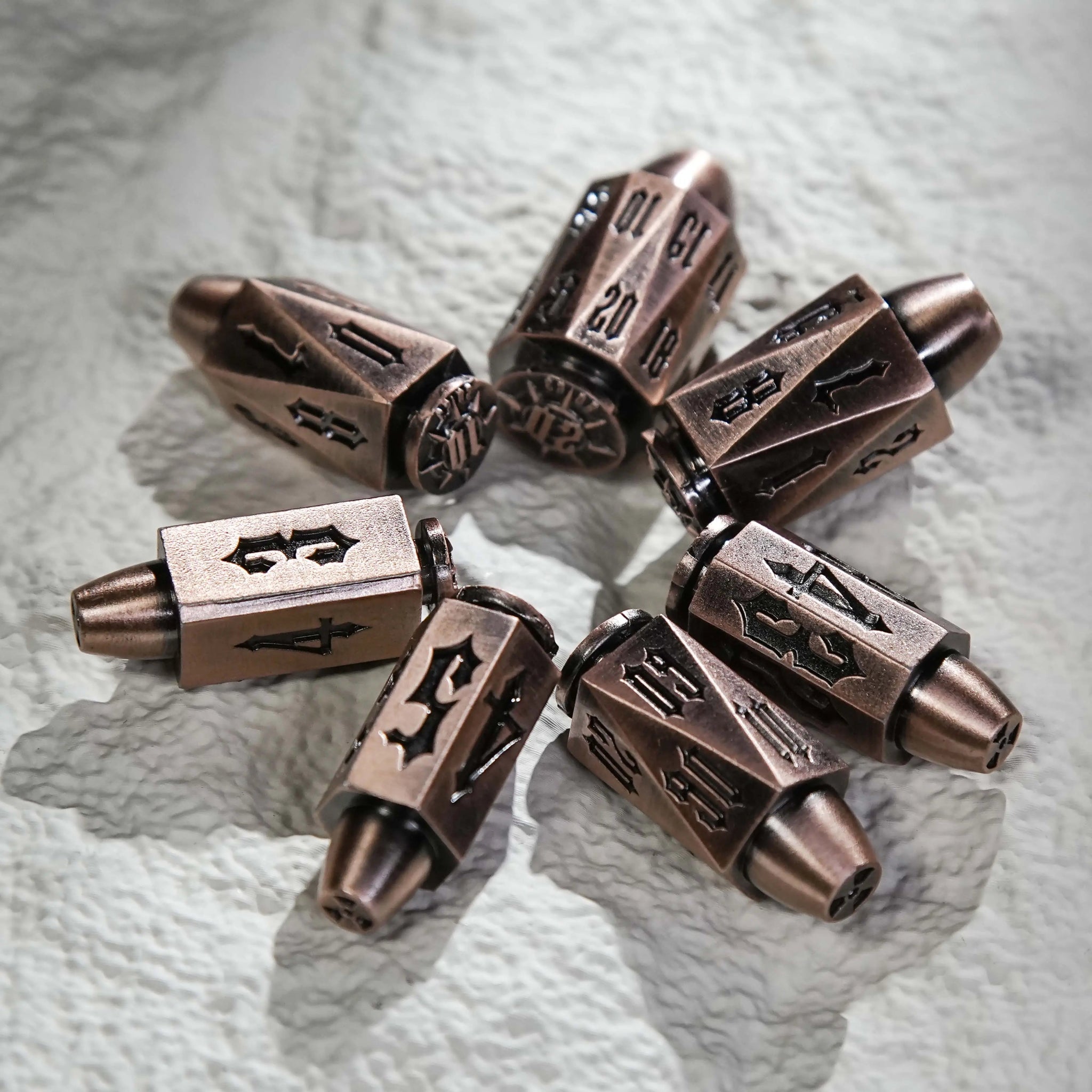 Cool DND Dice Set: Copper Polyhedron Metal Bullet Dice arranged in a circle on the table. Unique Bullet-Shaped RPG Dice | Bear Dice