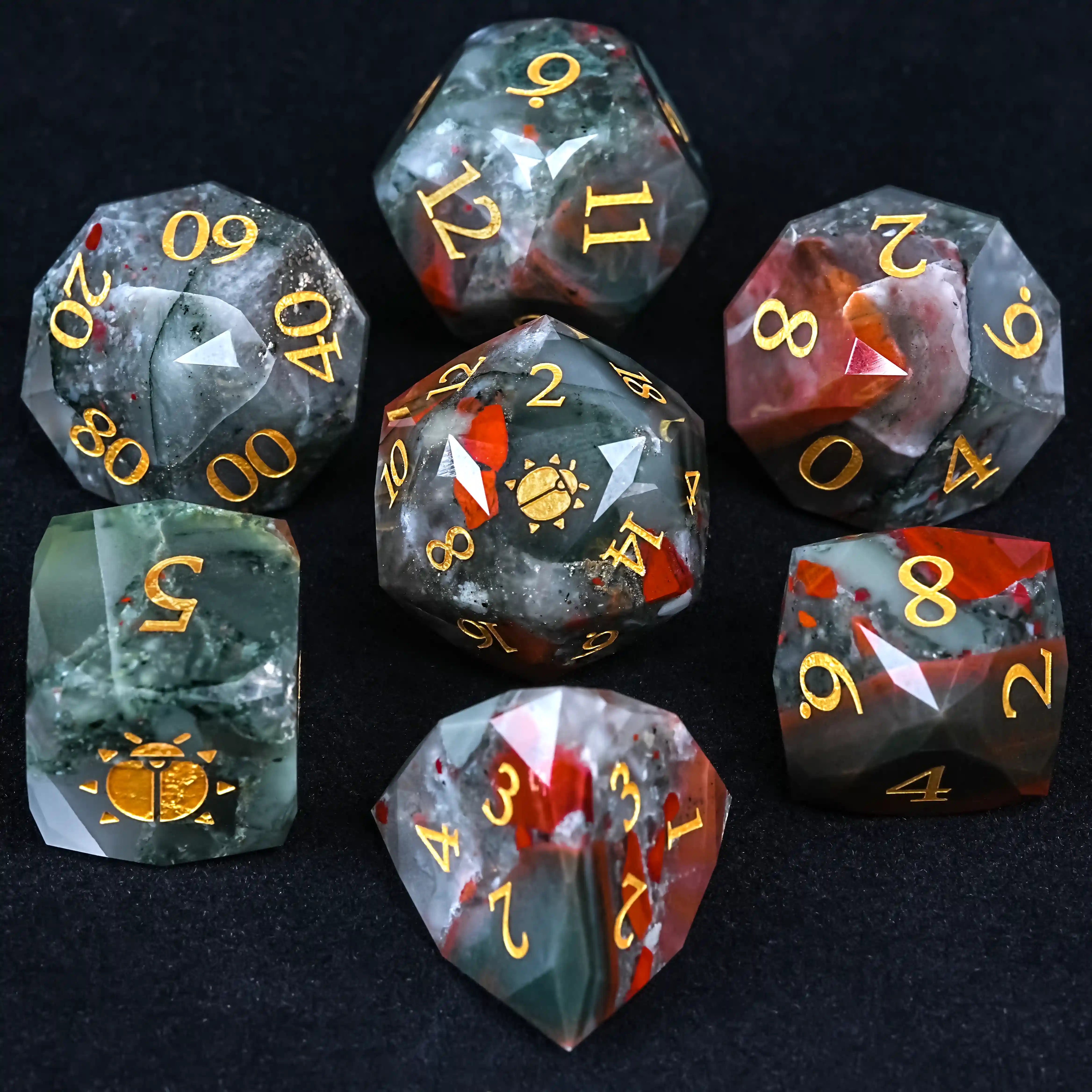 Natural Bloodstone DND Gemstone Dice Set, featuring shapes from D4 to D20, gold - colored font with a sun - beetle pattern, designed for tabletop gaming adventures.