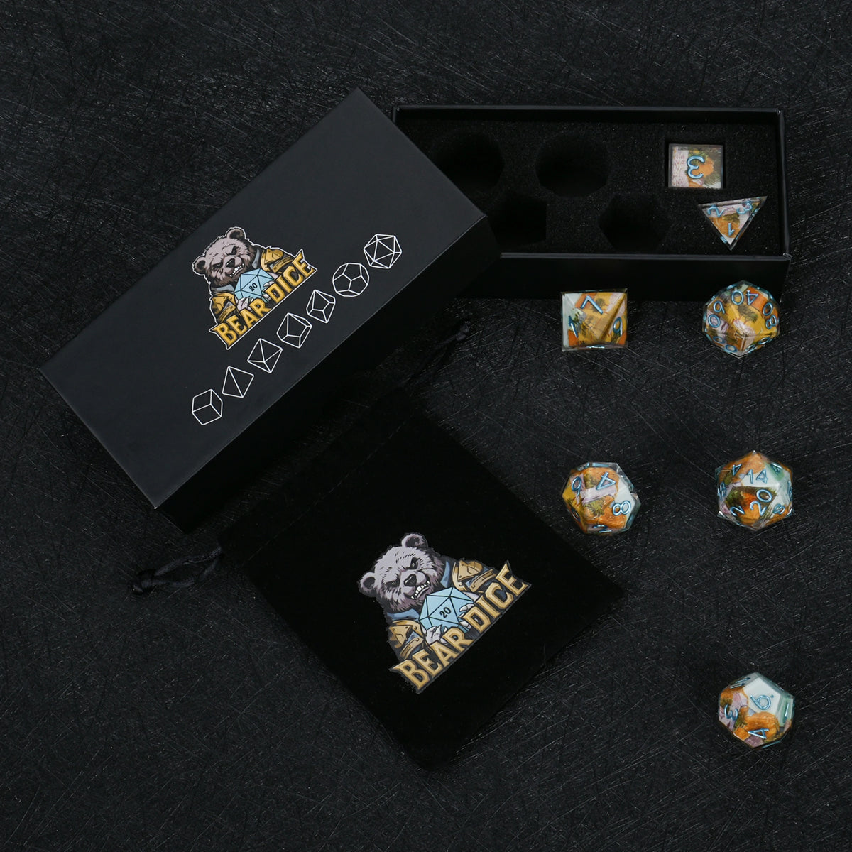 Seven autumn landscape resin dice with blue numbers, displayed with a black Bear Dice box, foam insert and drawstring pouch