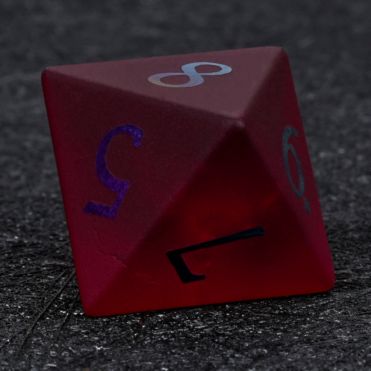 Garnet red frosted glass D8 die with rainbow-plated numbers, showing its angular shape and triangular faces