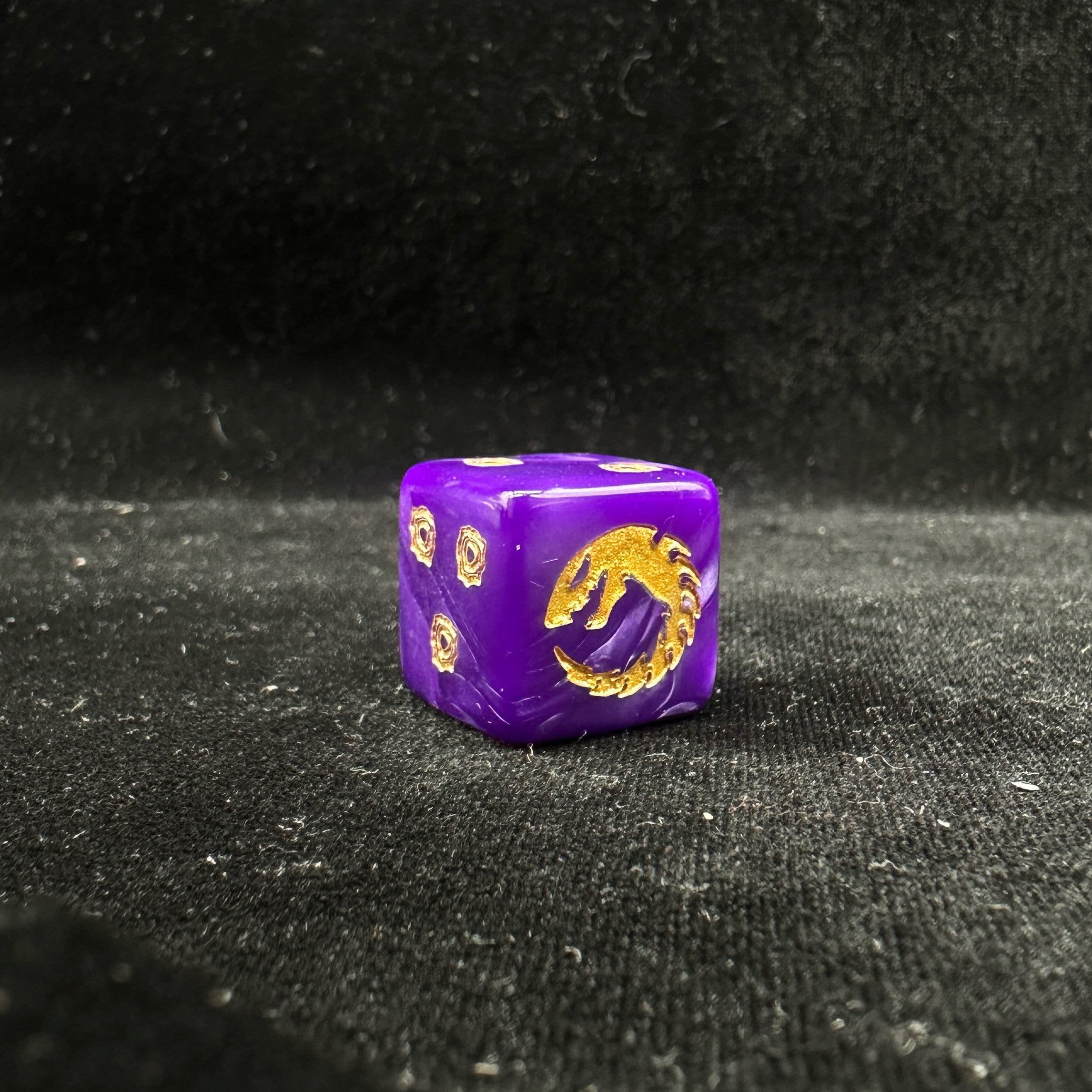 Genestealer Cults Ouroboros D6 Dice — Single Die Close-Up Showing Gold Ouroboros Dragon Emblem on 6-Face with Purple Pearl Acrylic Body and Gold Rune Pip Sides | Bear Dice