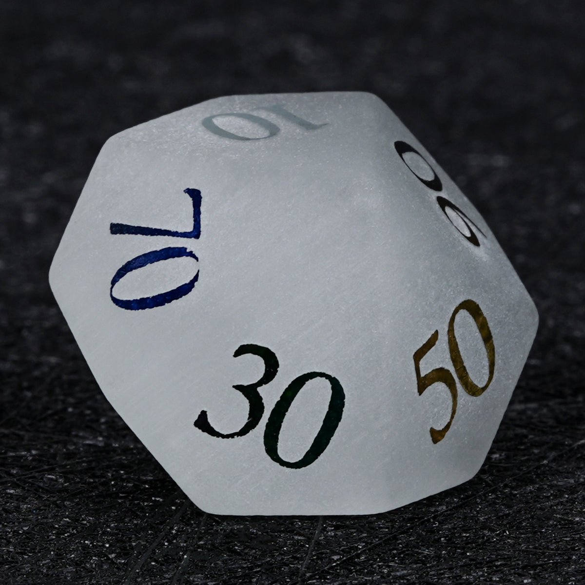 Gray frosted gemstone D100 percentile die with multicolored electroplated numbers, showing tens markings including 30 and 50.