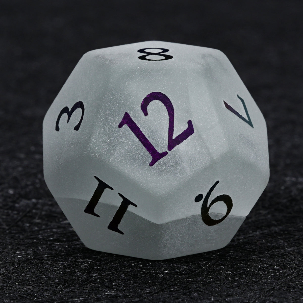 Gray frosted gemstone D12 die with multicolored electroplated numbers, showing its twelve-sided shape against a black background.