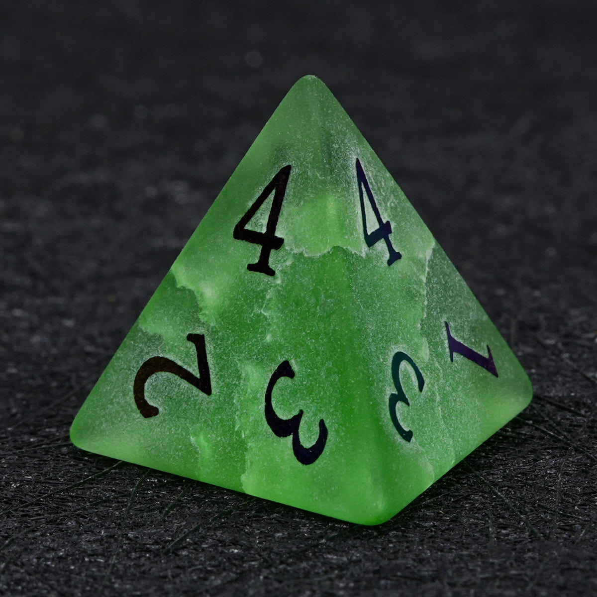 Green crackle frosted glass D4 die with multicolored electroplated numbers, showing its triangular pyramid shape on a black background.