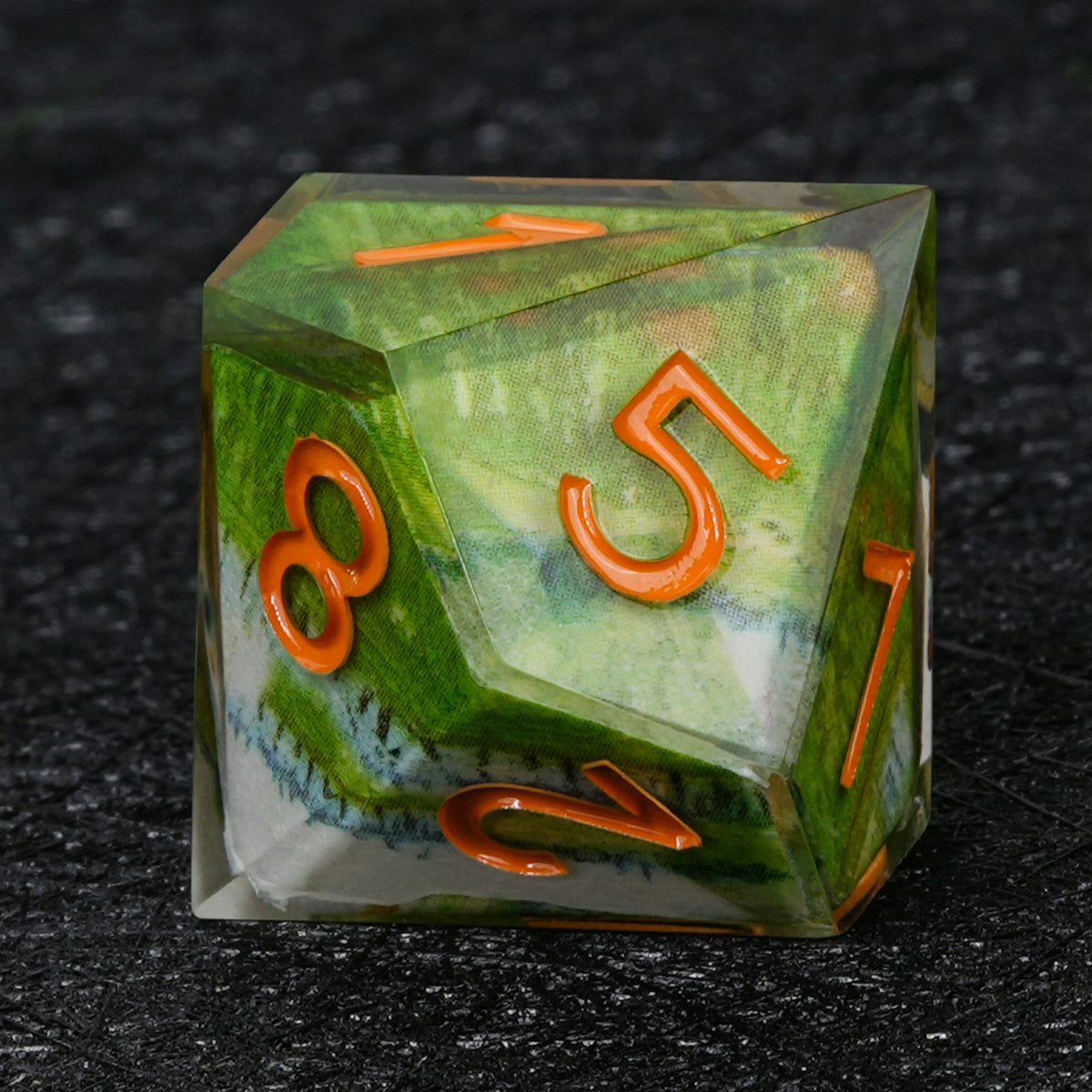Ten-sided resin D10 with green landscape decal artwork, pale white accents and orange numbers
