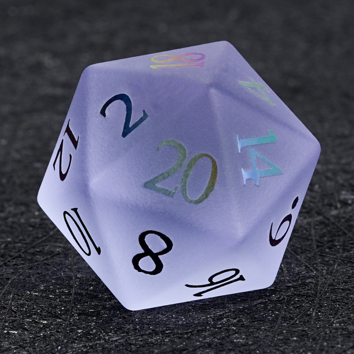 Translucent lavender gemstone D20 die with multicolored numbers, shown close up on a textured black surface