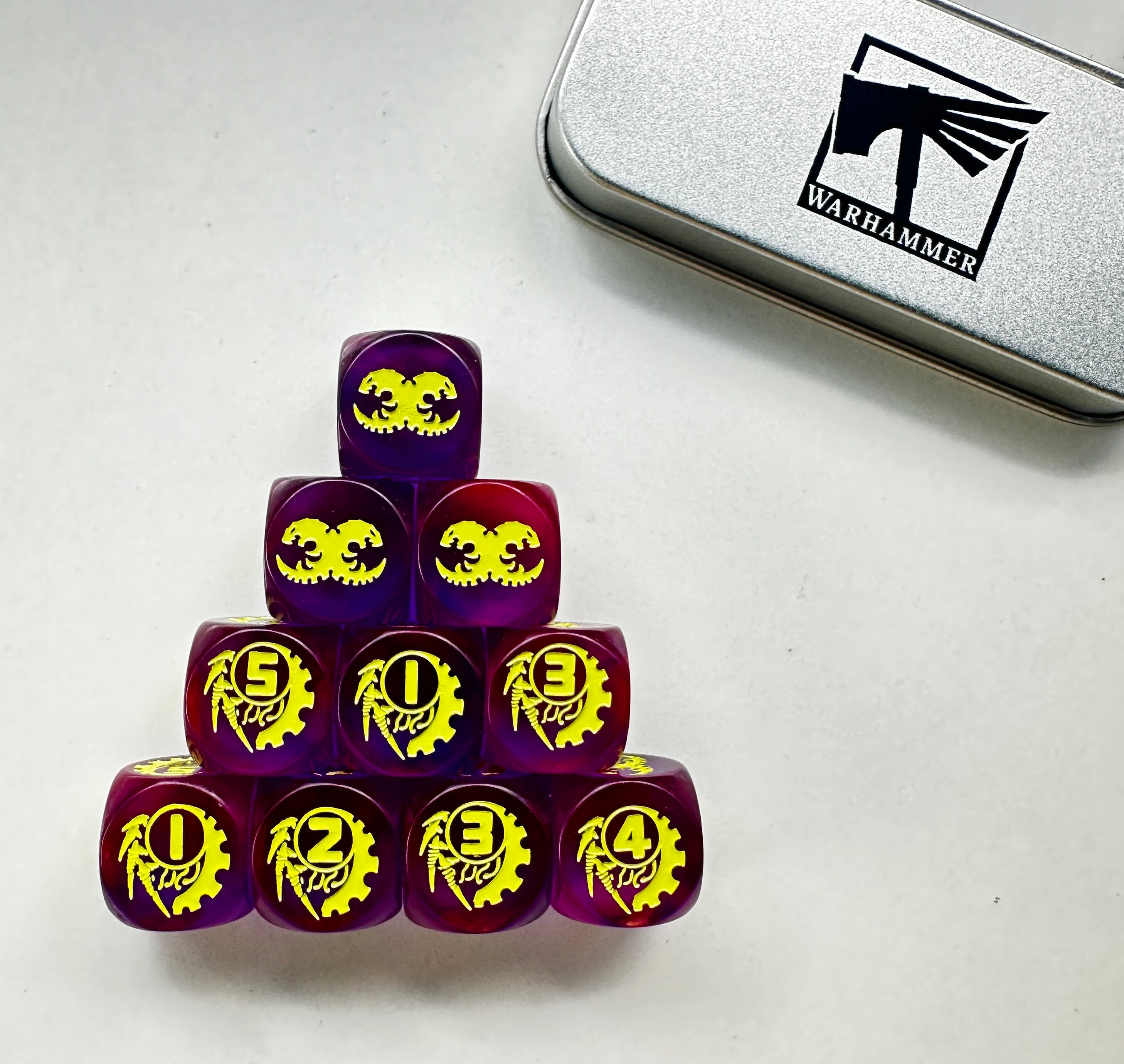 Warhammer 40K Tyranid Purple Transparent Acrylic D6 Dice Set of 10 — Pyramid Stack on White Background Showing Dual-Claw Skull 6-Face and Yellow-Green Gear Numeral Pip Faces | Bear Dice